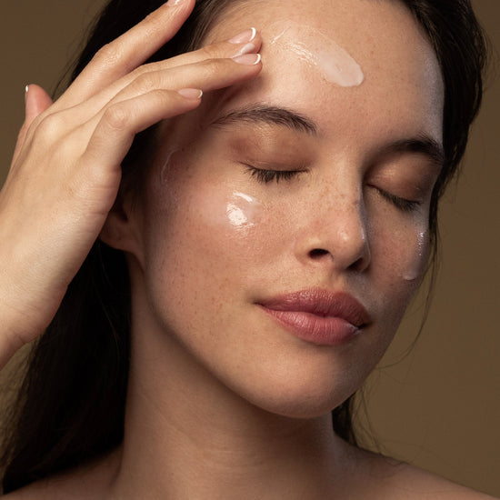 A woman applies Antipodes Culture Probiotic Night Cream on her face