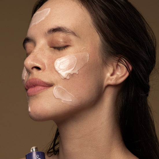 A woman applies Antipodes Flora Probiotic Skin-Rescue Hyaluronic Mask on her face