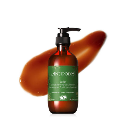 A pump bottle of Antipodes Juliet Daily Balancing Gel Cleanser with a brown tinted liquid visible inside the bottle, against a white background.