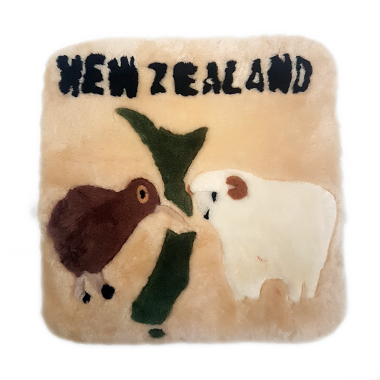 A square-shaped cushion with a kiwi and a sheep design, predominantly in green and brown tones, with the text 'NEW ZEALAND' at the top.