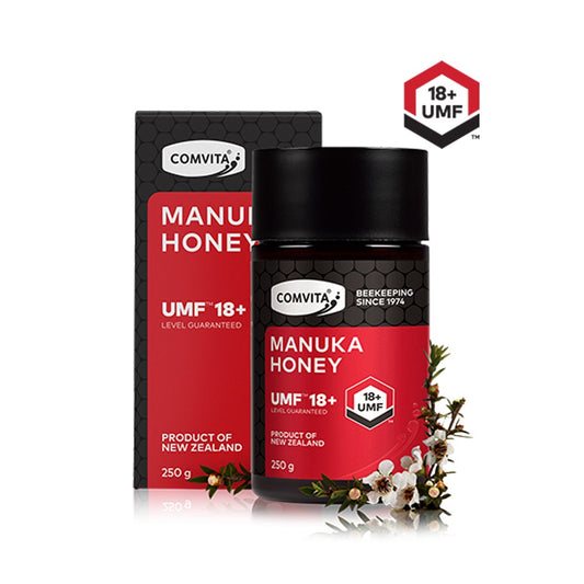 A pack of Comvita UMF 18+ Manuka Honey in a 250g red sachet with a black lid, displayed alongside its packaging box which is also red with the brand and product name visible.